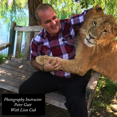 Peter Gatt playing with a lion cub during a photography workshop